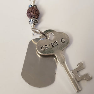 key-shaped charm with dog tag and brown lava bead