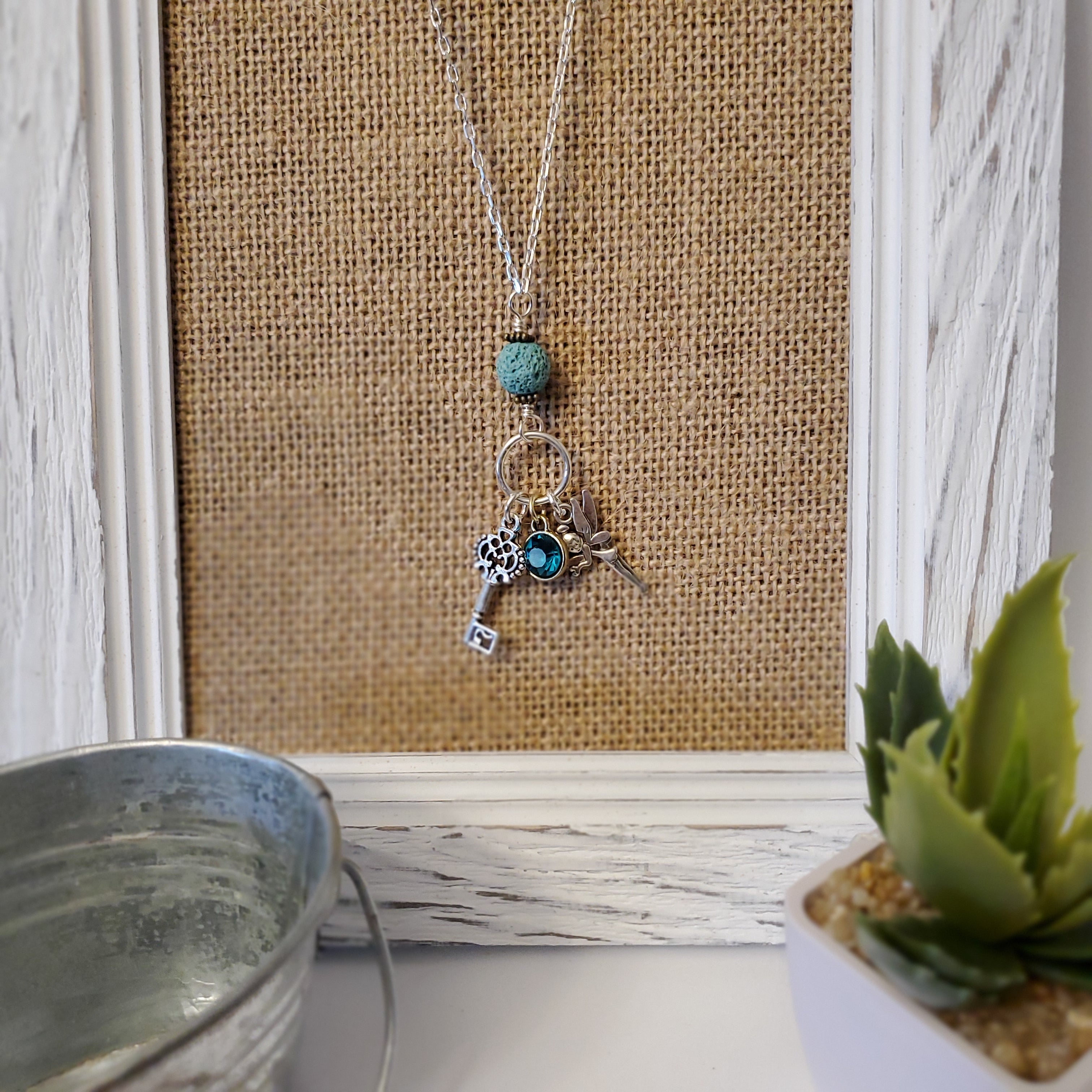 Long chain necklace with key charm and blue lava bead
