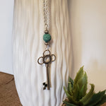 Key-shaped charm with light blue lava bead