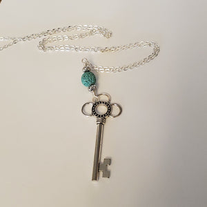 Key-shaped charm with light blue lava bead